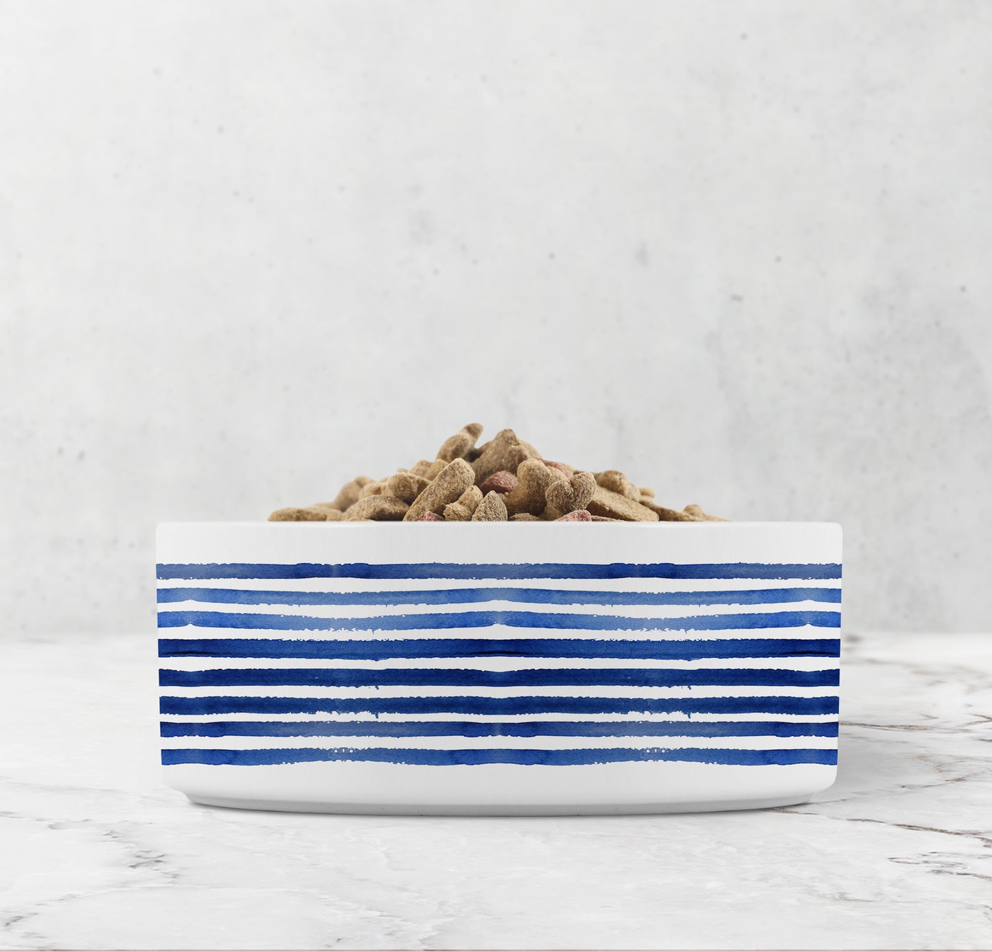 White bowl with blue stripes filled with pet food on a light gray background