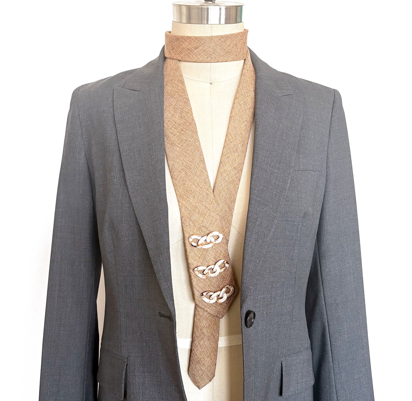 Camel linen embellished necktie with ivory decorative trim shown on mannequin with grey blazer