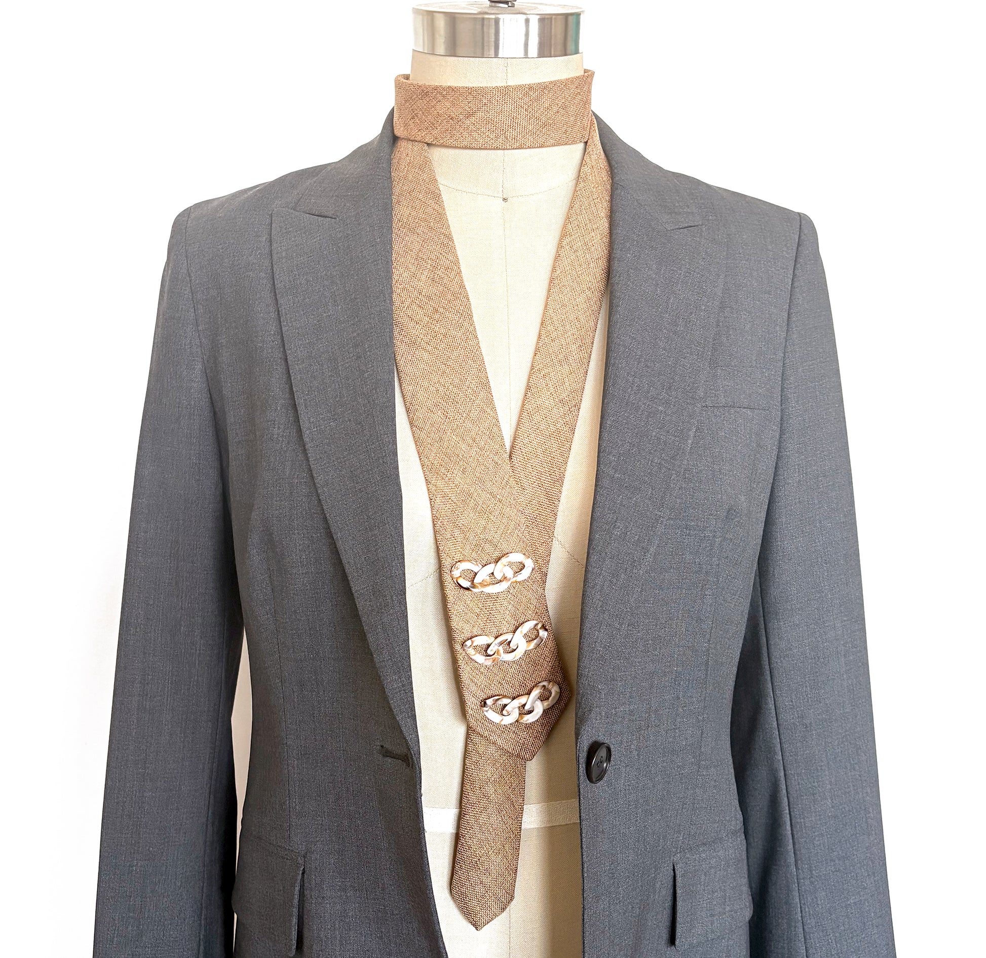 Camel linen embellished necktie with ivory decorative trim shown on mannequin with grey blazer