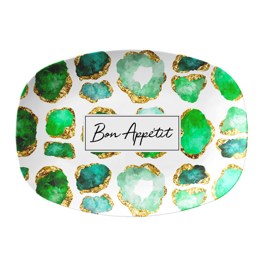 Oval serving platter has emerald green and gold gemstones printed on a white background. In the center there is a rectangle box to add personalized name or custom text.