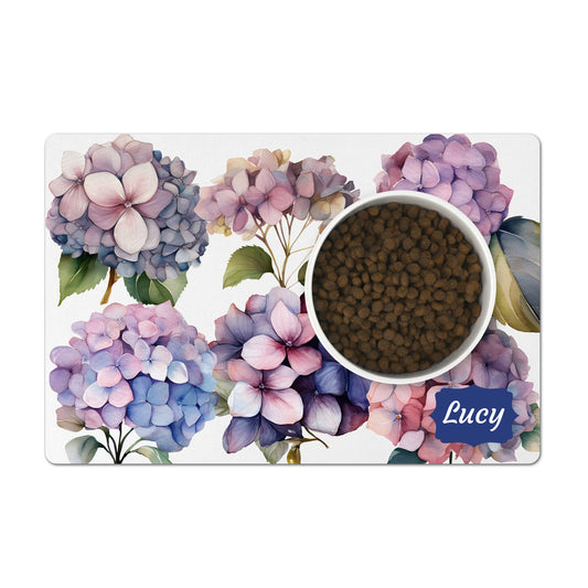 Pink and purple hydrangea flowers are printed on a white dog food mat personalized with any text.