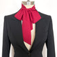 Black suit jacket with a red scarf tied around the neck on a mannequin against a white background