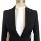 Black tuxedo with a white cravat on a mannequin against a white background