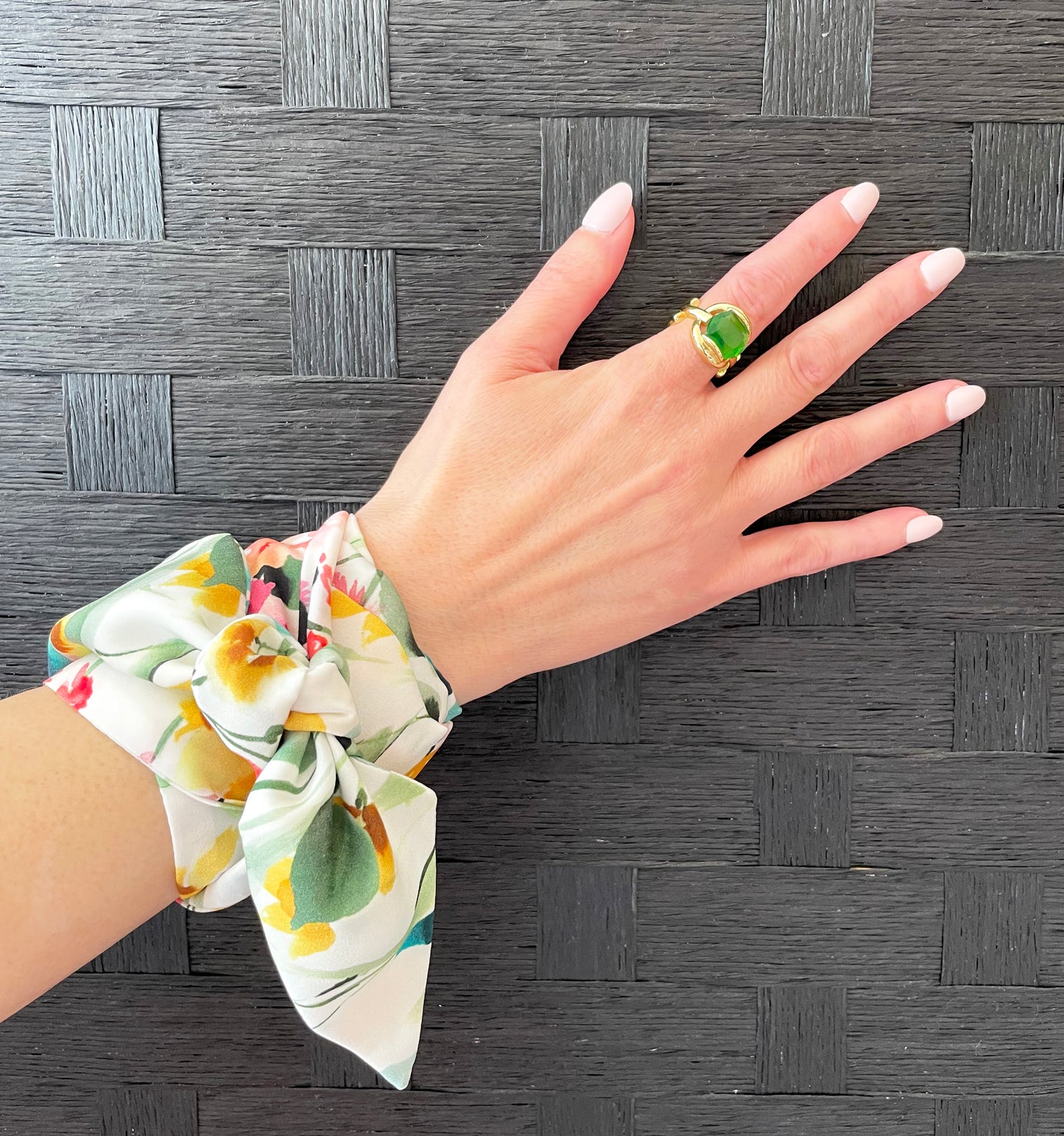 Thin floral scarf wrapped around wrist, worn as a bracelet.