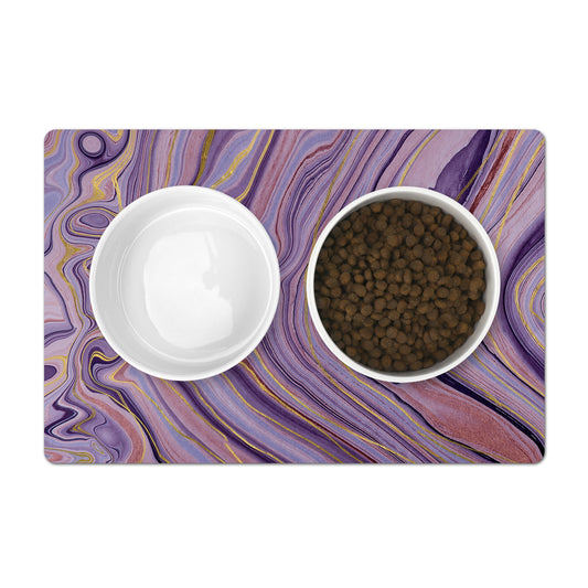 Pet food bowls on placemat with purple and gold marble swirls.