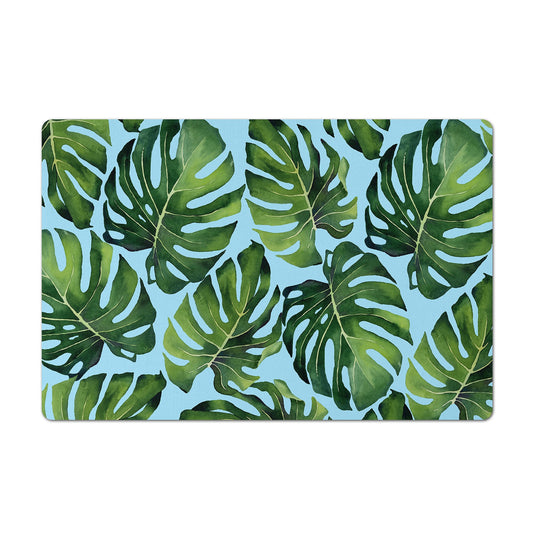 Pet food mat with monstera leaves print in aqua and green.