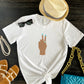 Peace Sign print t-shirt for women. Classic crewneck short sleeve tee features a hand wearing a glamorous aqua ring and a fabulous light blue manicure showing the peace sign. Fantastic gift for her.