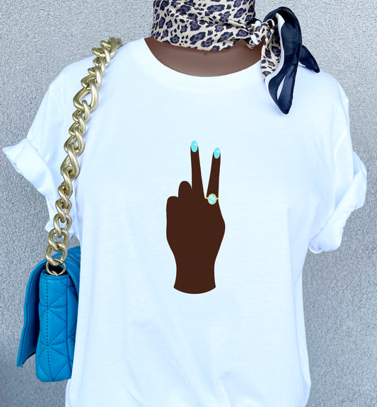 Peace Sign print t-shirt for women. Classic crewneck short sleeve tee features a hand wearing a glamorous aqua ring and a fabulous light blue manicure showing the peace sign. Fantastic gift for her.
